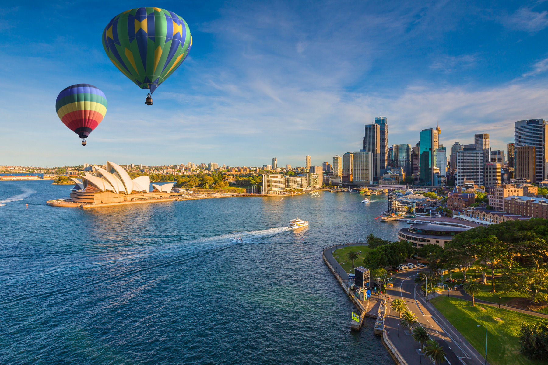 Hot air balloons above the ocean and Sydney Opera House.