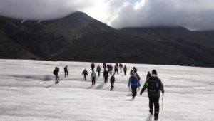 Student group hikes across icy landscape.