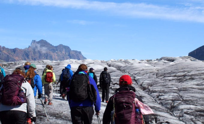 Group hikes across rocky landscape.