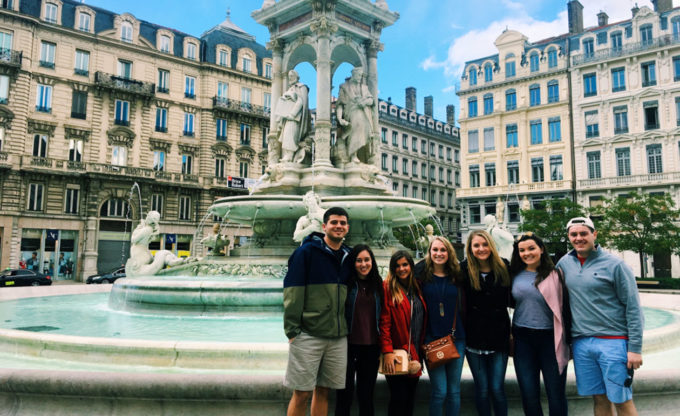 Group stands near fountain in Paris.