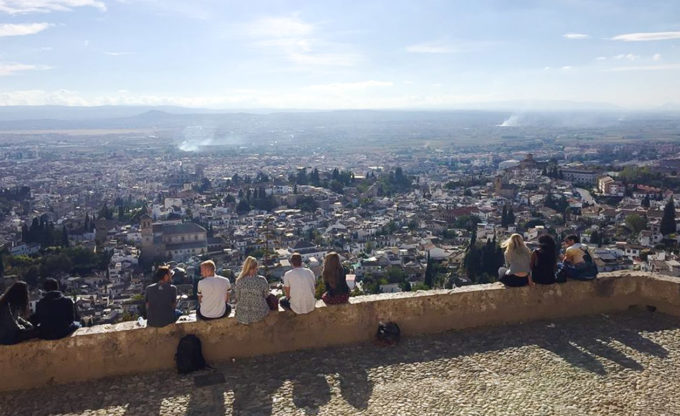 Students sit on wall overlooking San Miguel Alto.