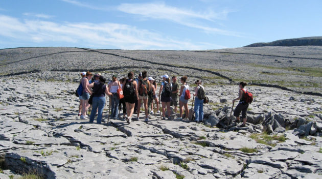 Group of students hikes across rocky landscape.