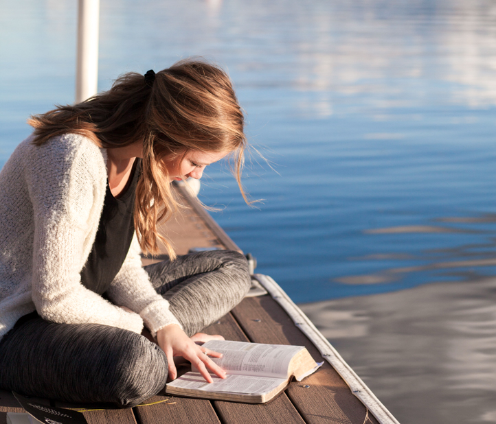 Woman reads on dock.